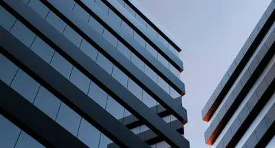 A modern building with large glass windows and sustainable green roof, reflecting the trends in eco-friendly architecture.